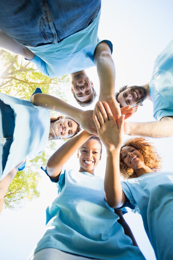 Portrait of volunteer group forming huddles